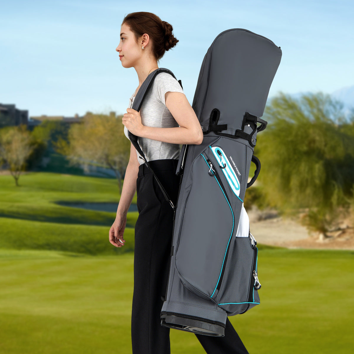 Woman carrying the grey golf cart bag over her shoulder on a golf course