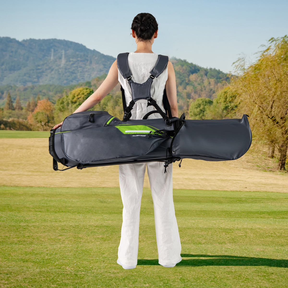 The golf stand bag being worn by a person on a golf course, viewed from behind