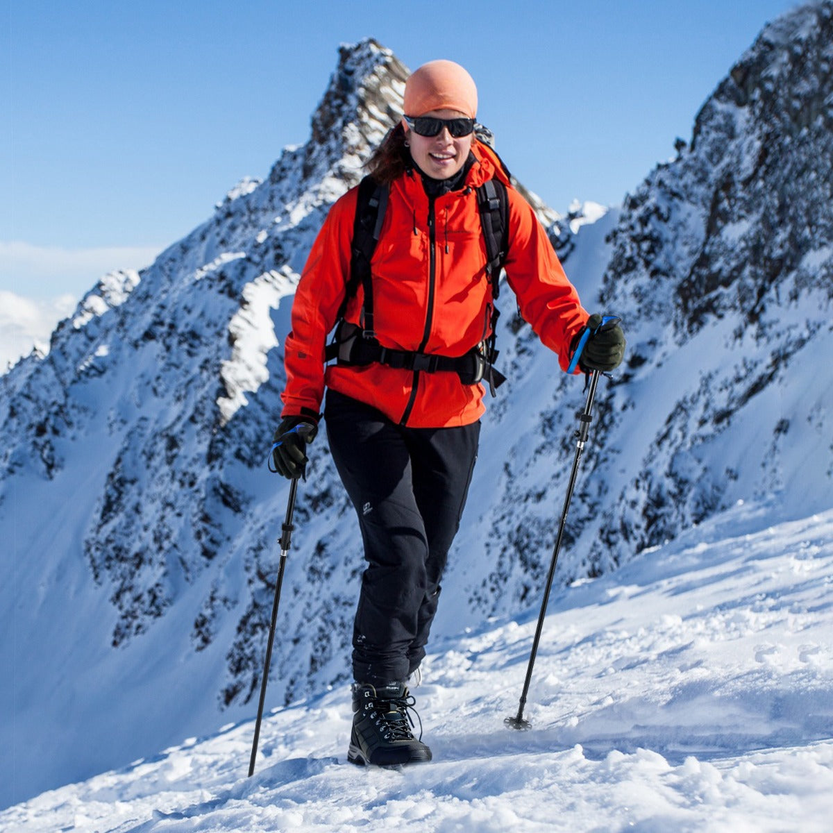 The walking sticks being used by a woman hiking up a snowy mountain