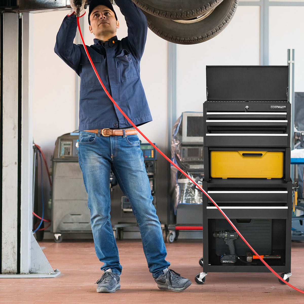 A man uses the black tool storage cabinet with wheels in a garage setting
