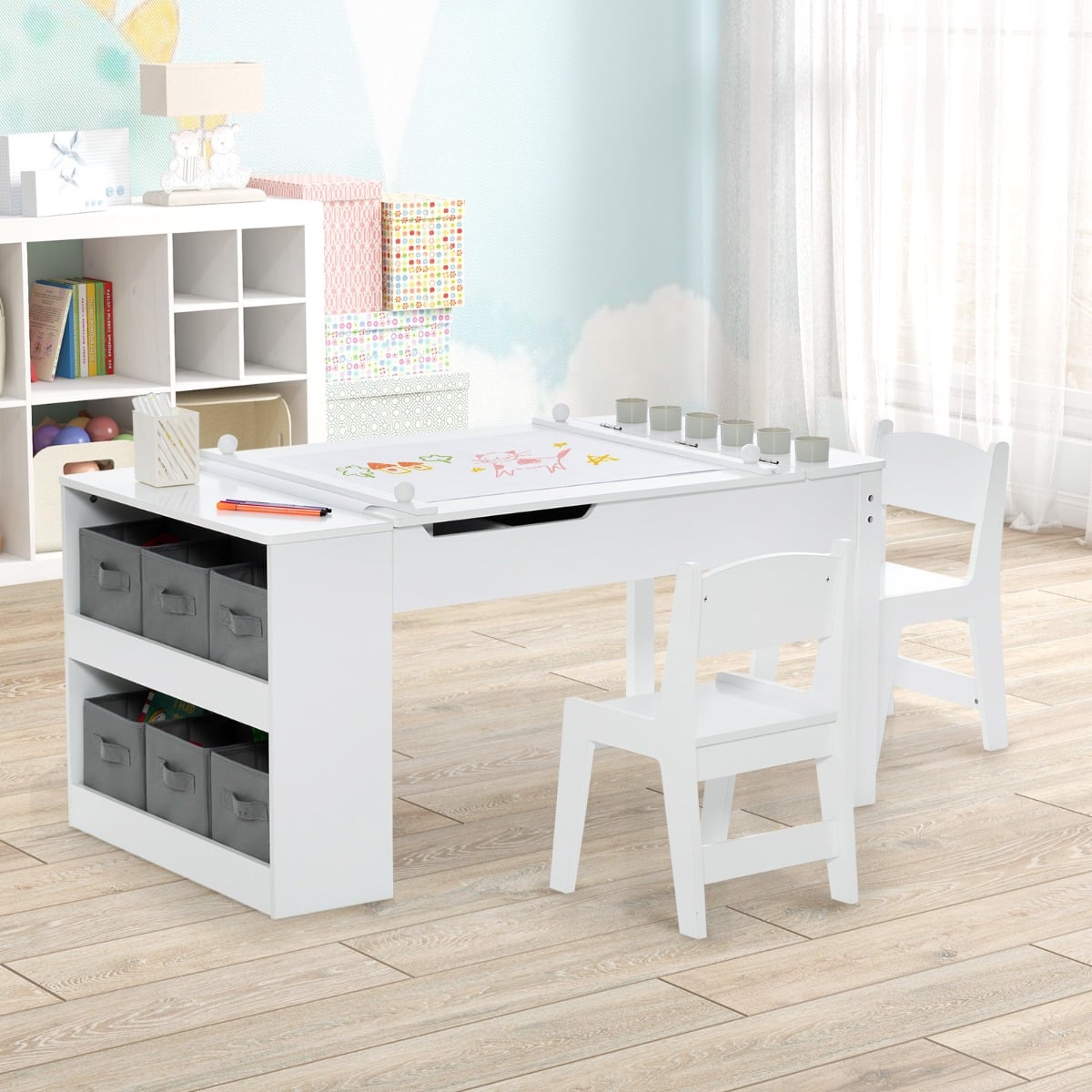 Children's art table set with chairs and storage bins in a bright playroom