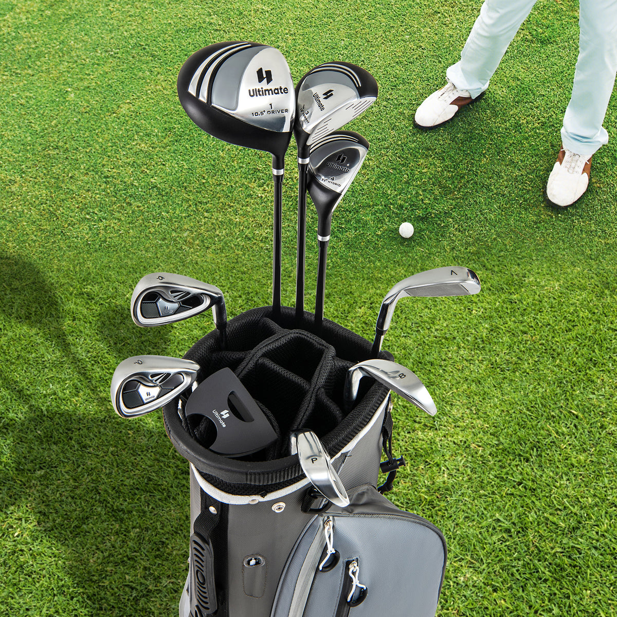 The golf clubs arranged inside the grey carry bag standing on a green grass golf course