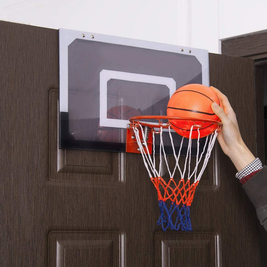 The mini basketball hoop with shatterproof backboard being used indoors, a hand is about to shoot a ball