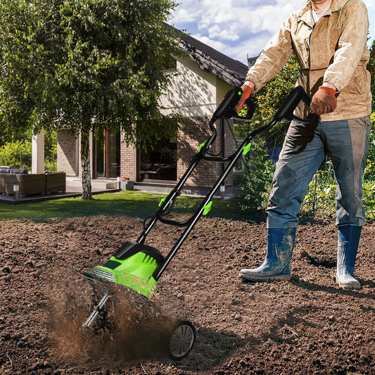 The green cultivator with foldable handle is shown from the front with its tines digging into the soil