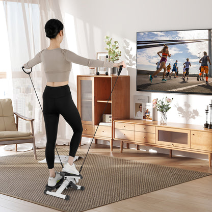 Woman using the portable hydraulic stepper with resistance bands in a living room
