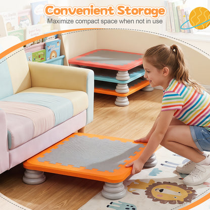 The square trampoline being slid under a sofa for storage by a young girl in a playroom