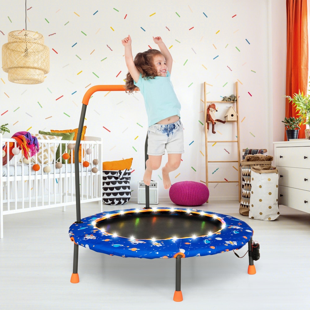 The blue children's trampoline in a nursery room with a child jumping