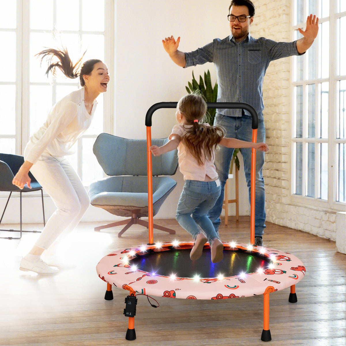 The kids trampoline in use by a child while parents jump in a bright living room setting