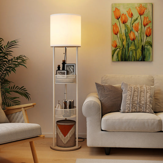 The white floor lamp with shelves is shown in a living room next to a sofa and armchair