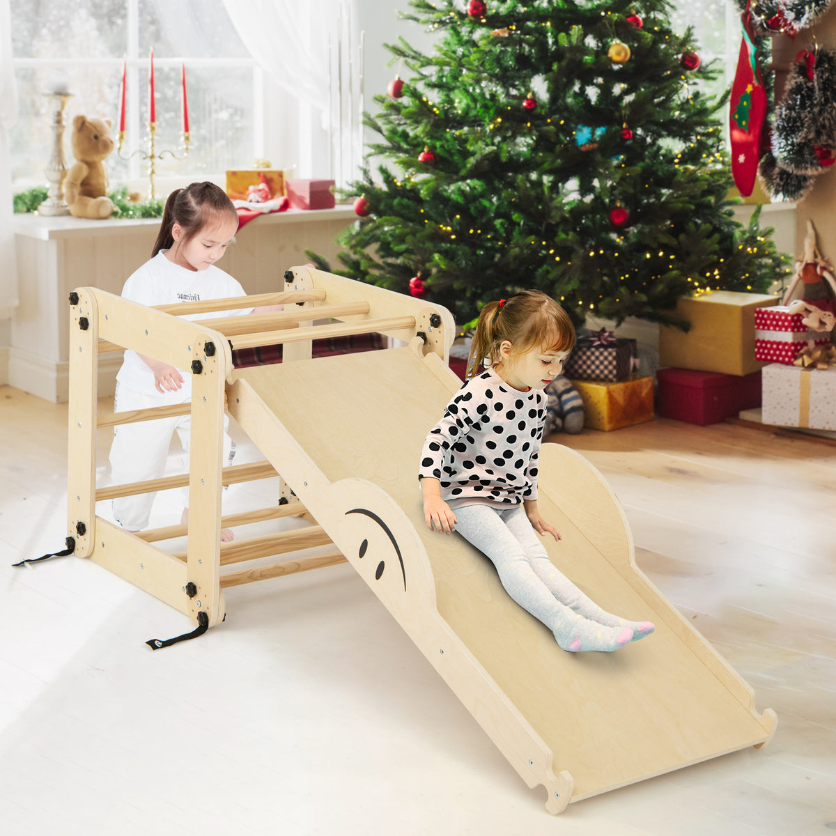 Toddlers enjoying the wooden climbing frame with slide and ladder during Christmas time