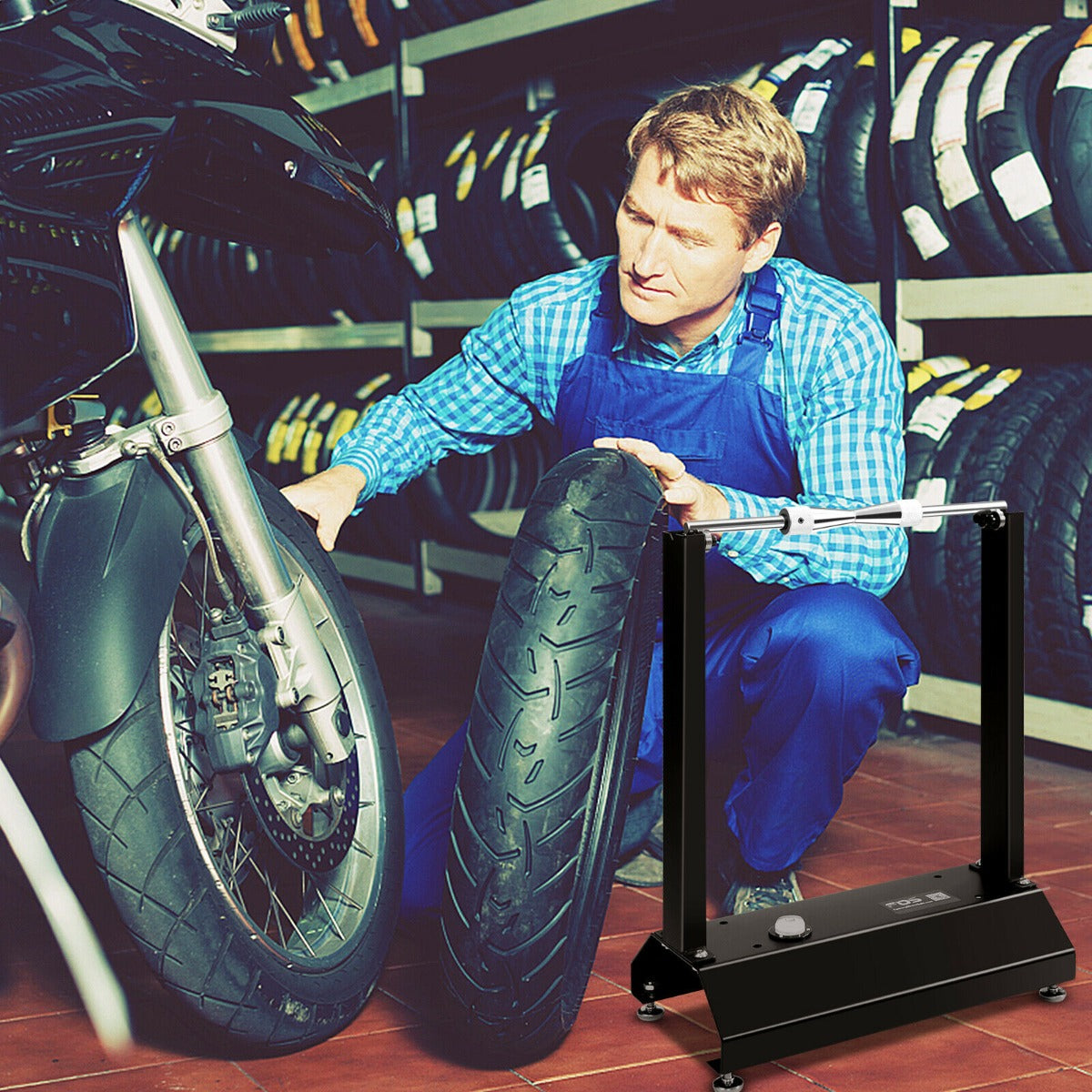 Mechanic in a garage using the motorcycle wheel balancer with adjustable centering cones on a motorcycle wheel