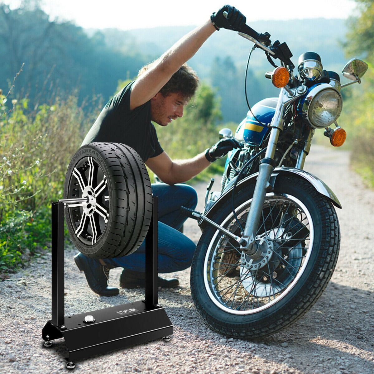 Man using the motorcycle wheel balancer with adjustable centering cones to balance a motorcycle wheel outdoors