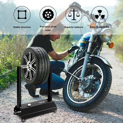The wheel balancer showing stable structure and precision shaft with a motorcycle wheel mounted