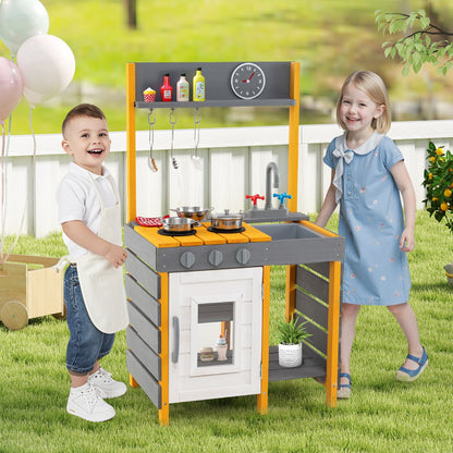 Two children playing with the grey mud kitchen set in a garden