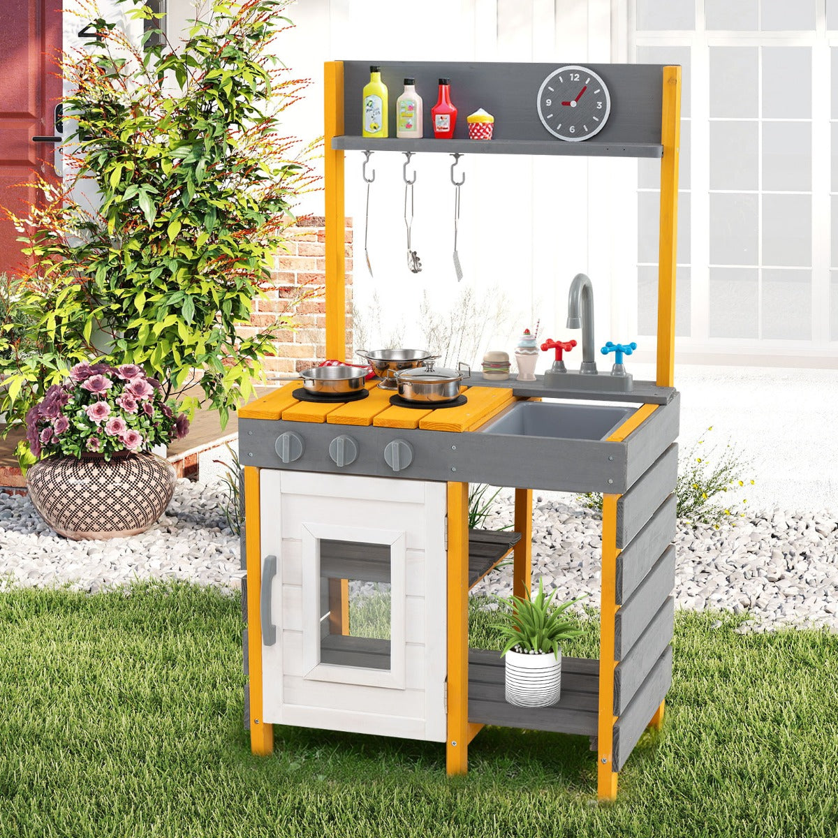 Grey mud kitchen set with a sink and faucet in a garden setting