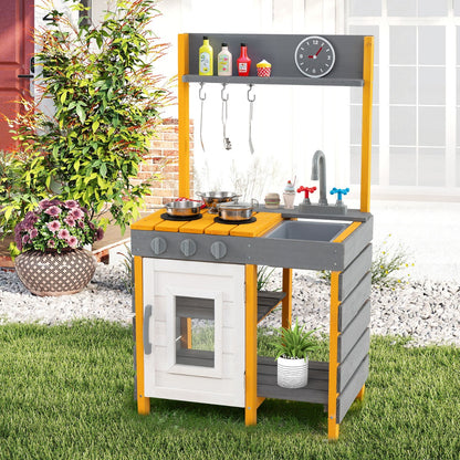 Grey mud kitchen set with a sink and faucet in a garden setting