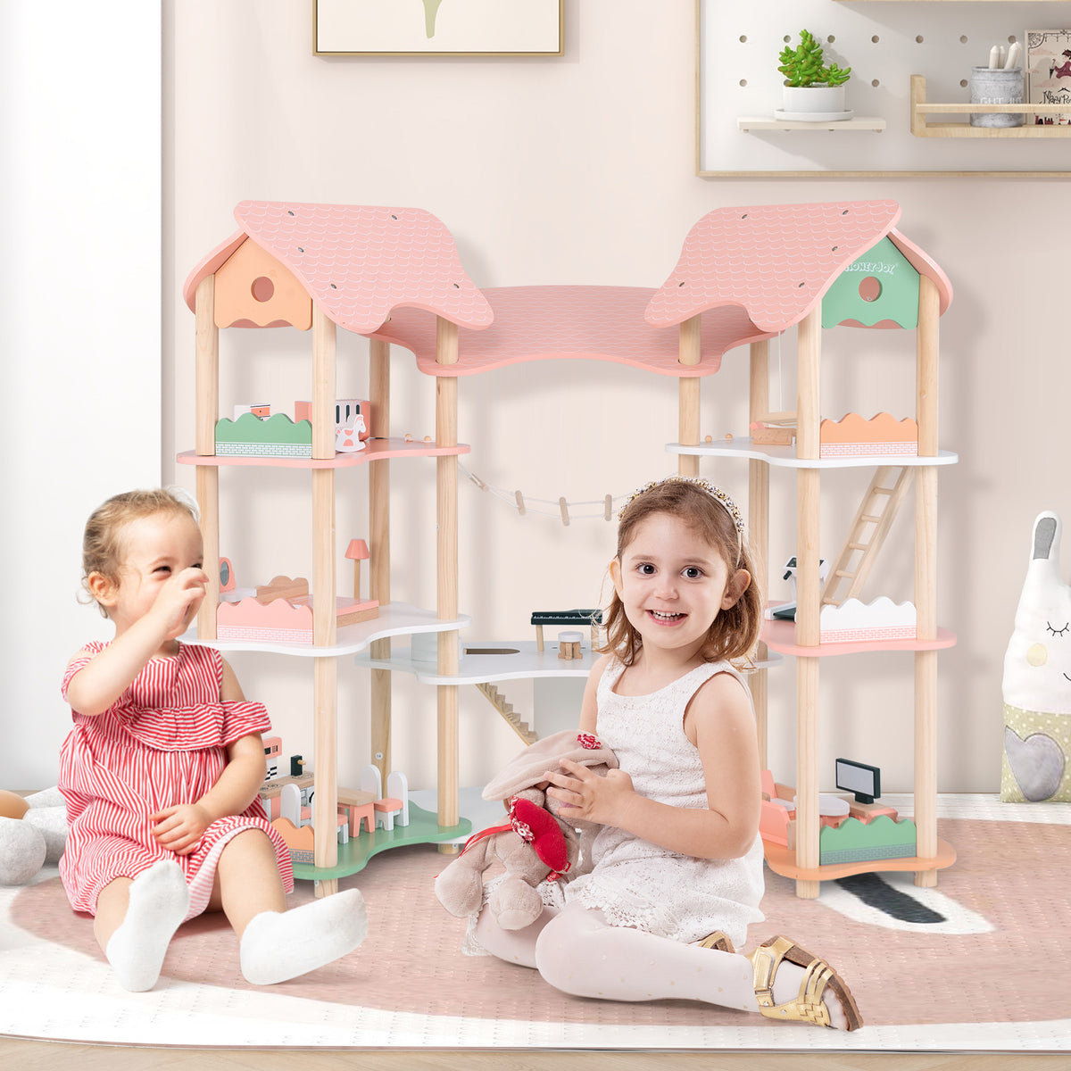 Two children playing with the pink dollhouse playhouse on the floor