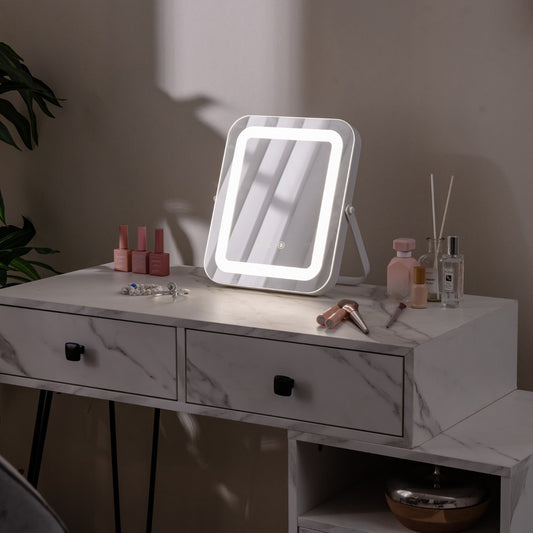 The illuminated makeup mirror sits on a marble-effect dressing table with cosmetics arranged around it