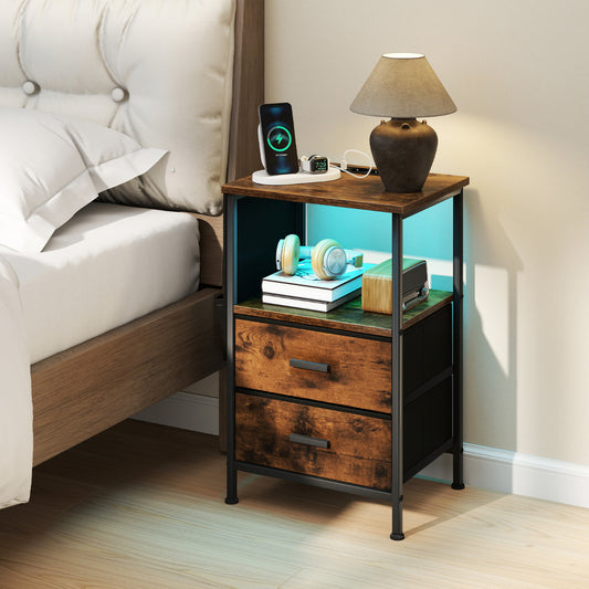 Rustic brown nightstand with charging station next to a bed, with a lamp and books on top