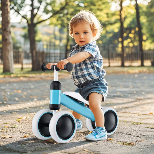 A toddler rides the blue balance bike outdoors on a paved path