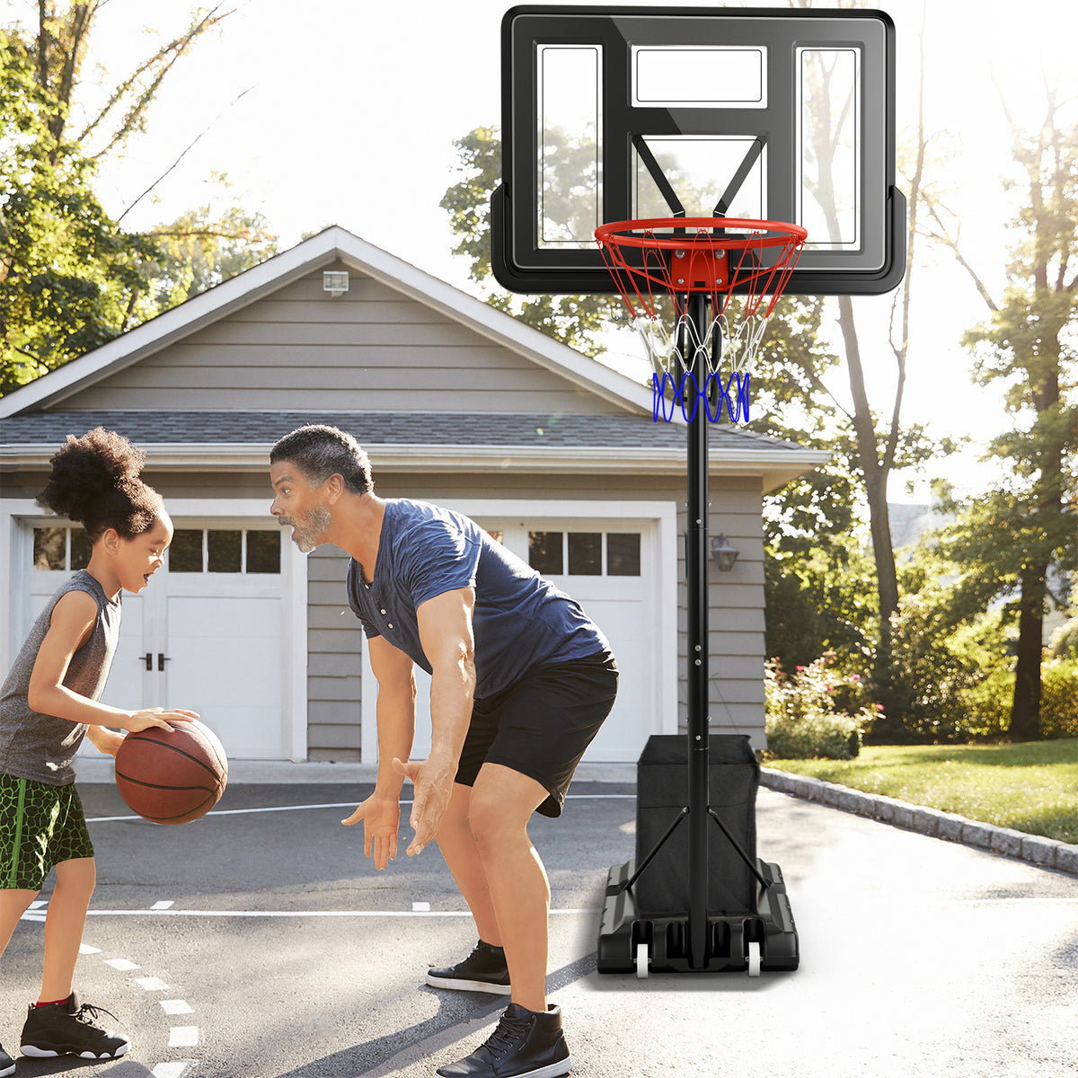 The sport equipment placed on a driveway while a father and daughter play basketball