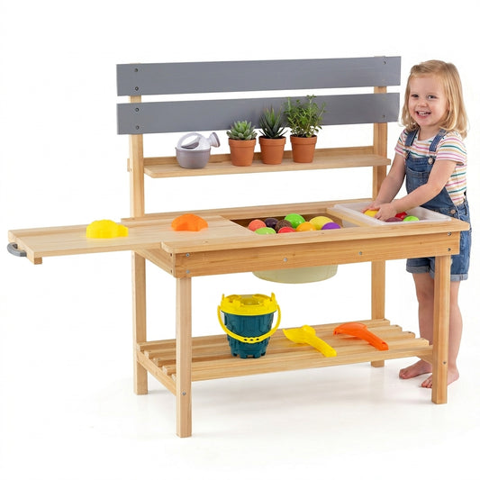 A young girl plays with the wooden outdoor mud kitchen, adding items to the sink