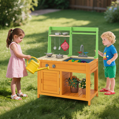Two children playing with the orange and green play kitchen set in a garden