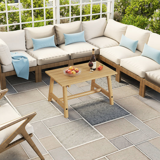 The wooden coffee table sits on a patio surrounded by outdoor seating