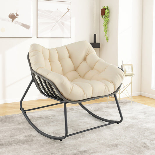 The patio rocking chair placed in a bright living room with a rug and wall art