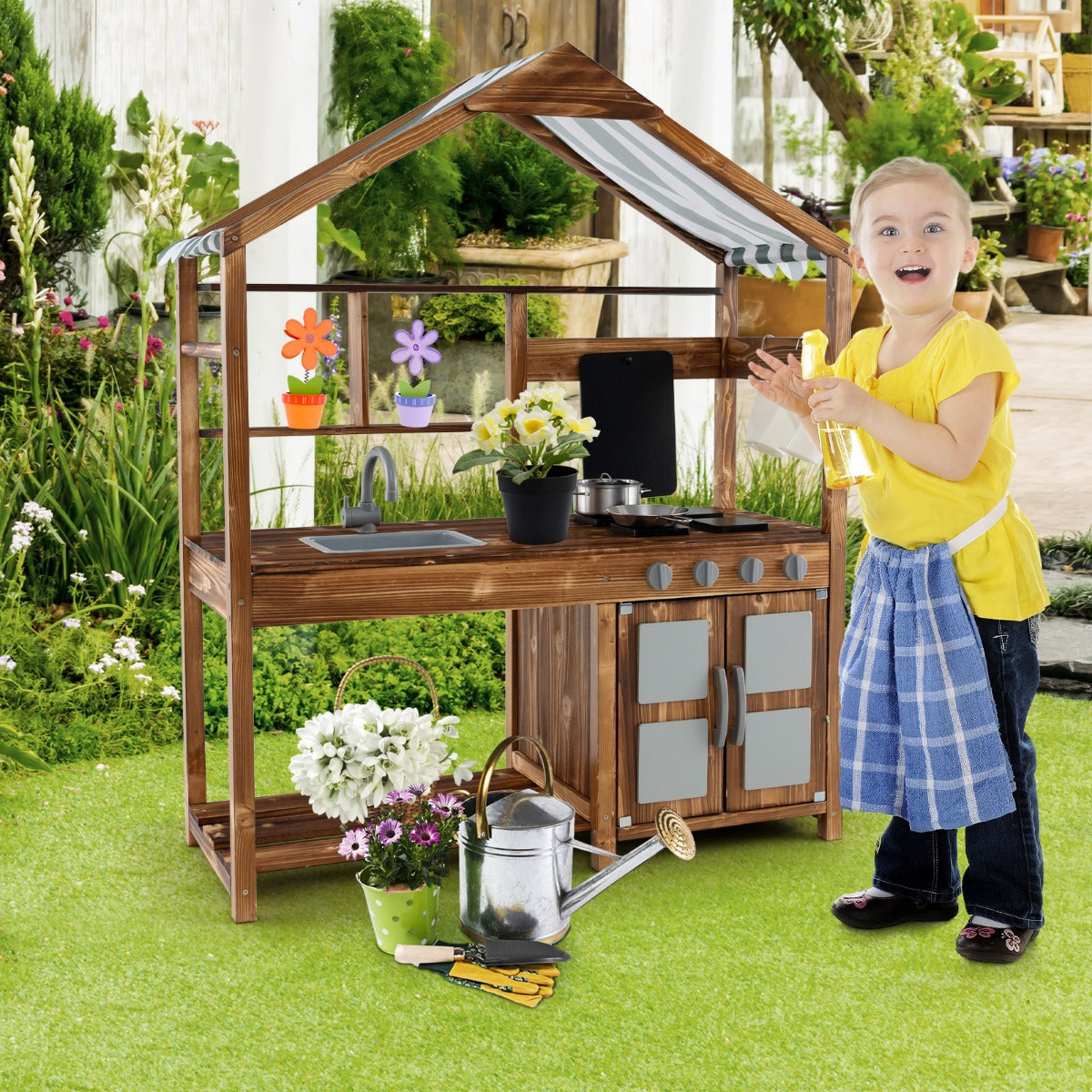 A young girl plays with the outdoor solid wood mud kitchen in a garden setting
