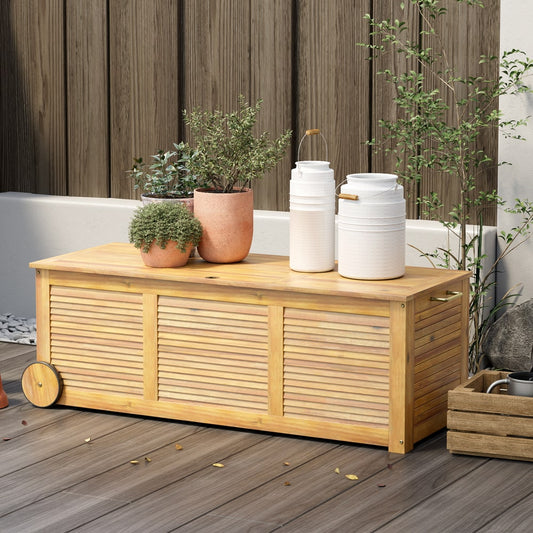 The outdoor storage box placed on a wooden patio with potted plants on top
