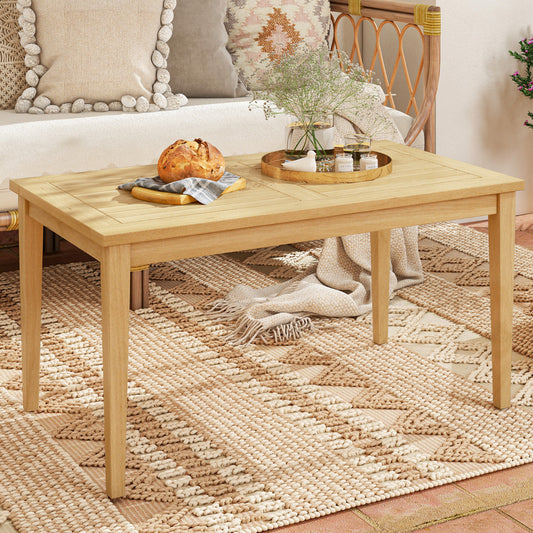 The patio table set on a rug indoors with a sofa in the background