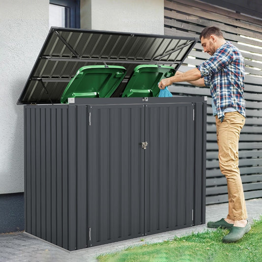 The outdoor storage shed with its lid open, showing two green bins inside