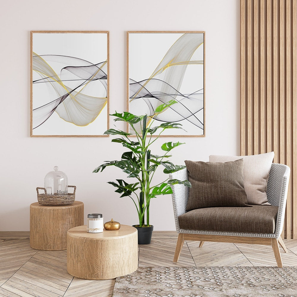 The artificial cheese plant sits in a stylish living room next to a chair and wooden side tables