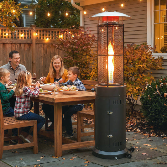 The patio heater standing on a patio next to a family eating dinner at an outdoor wooden table