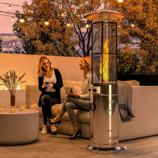 Two women sitting on a sofa next to the gas patio heater on a terrace