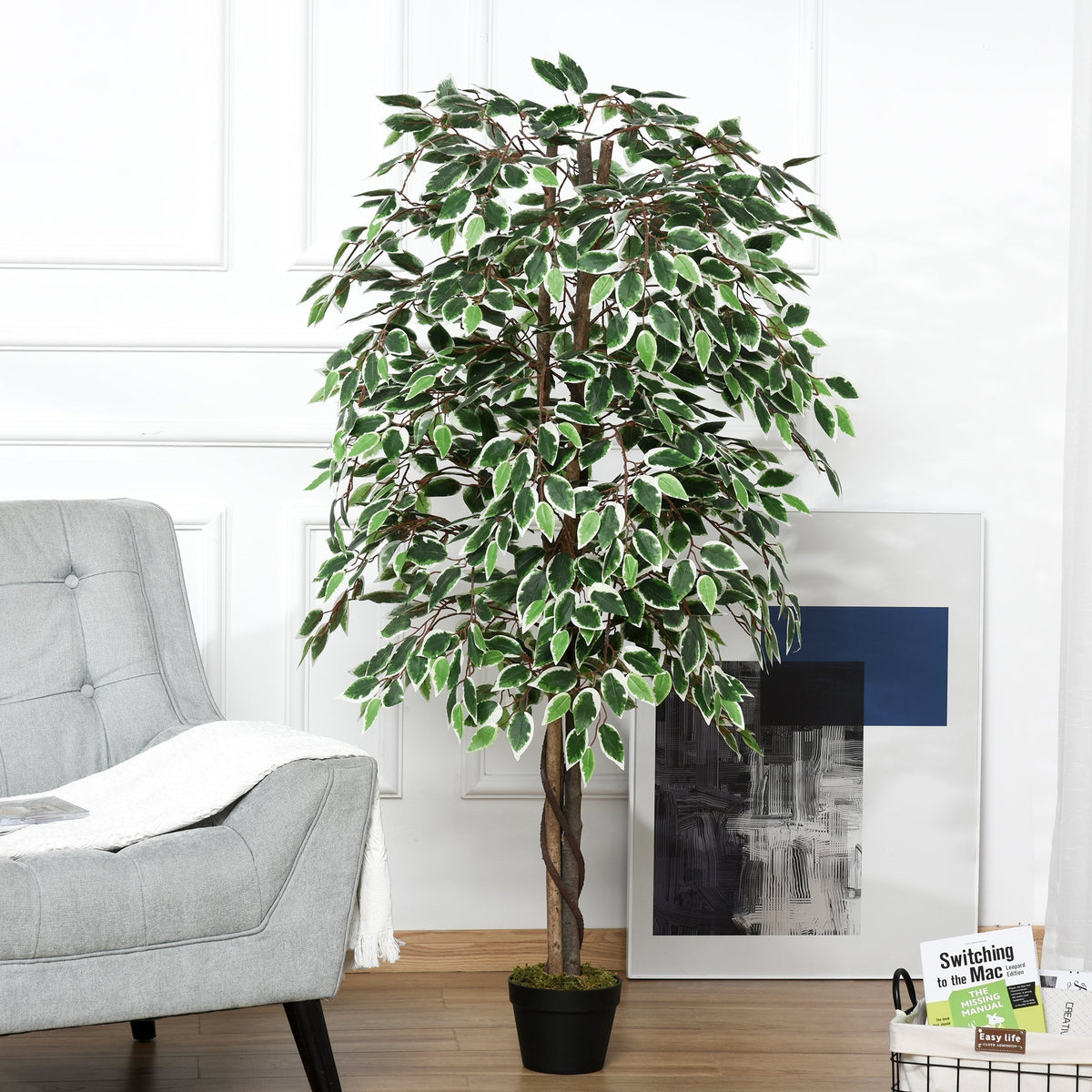 The artificial plants placed in a bright living room next to a grey armchair and wall art