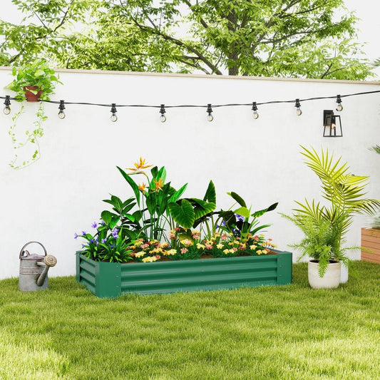The green galvanised steel open planter filled with plants sits on a lawn