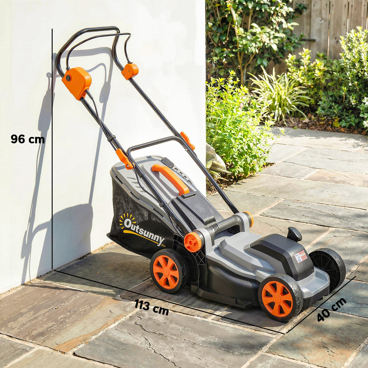 The cordless lawnmower standing against a wall with dimension lines indicating its size