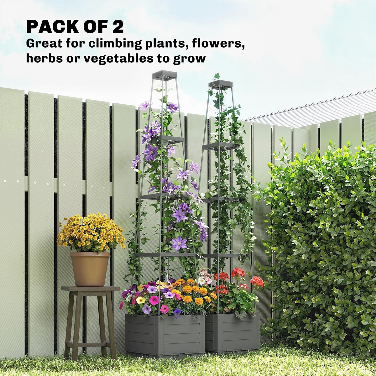 Two grey plastic planters with trellises in a garden, filled with colourful flowers