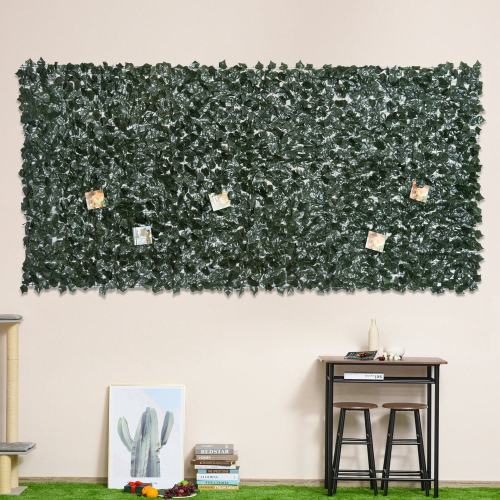 The artificial leaf fence panel used as a decorative wall covering indoors with pictures attached