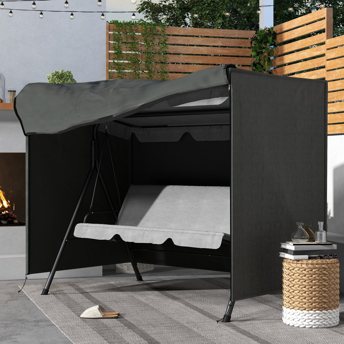 The protective cover placed over a swing seat on a patio next to a fireplace