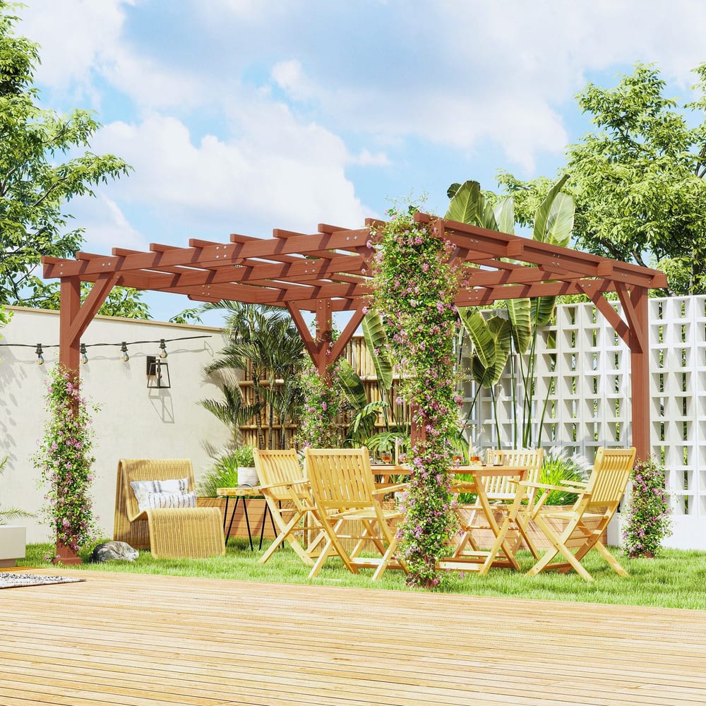 The wooden garden pergola kit set up in a garden with chairs and a table underneath, surrounded by plants and flowers