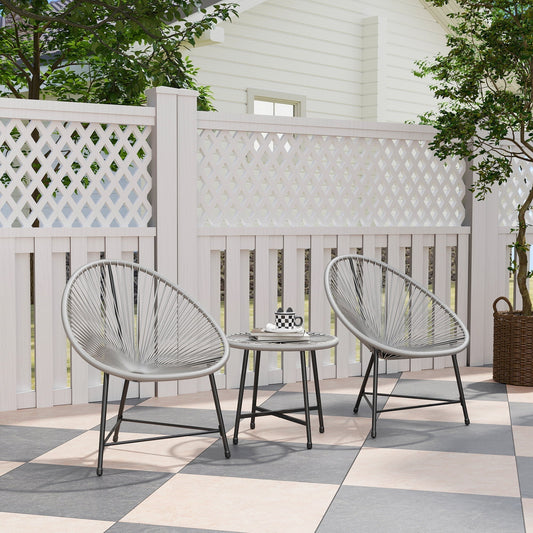Two grey rattan chairs and a small table on a patio