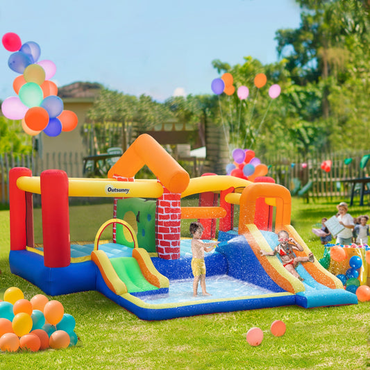 Children playing in the inflatable bouncy castle with slides and pool in a garden setting