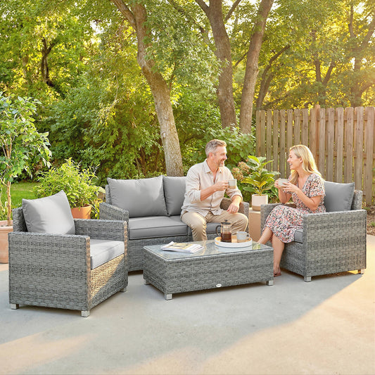 A couple enjoying drinks on the grey rattan garden furniture set with loveseat and armchairs