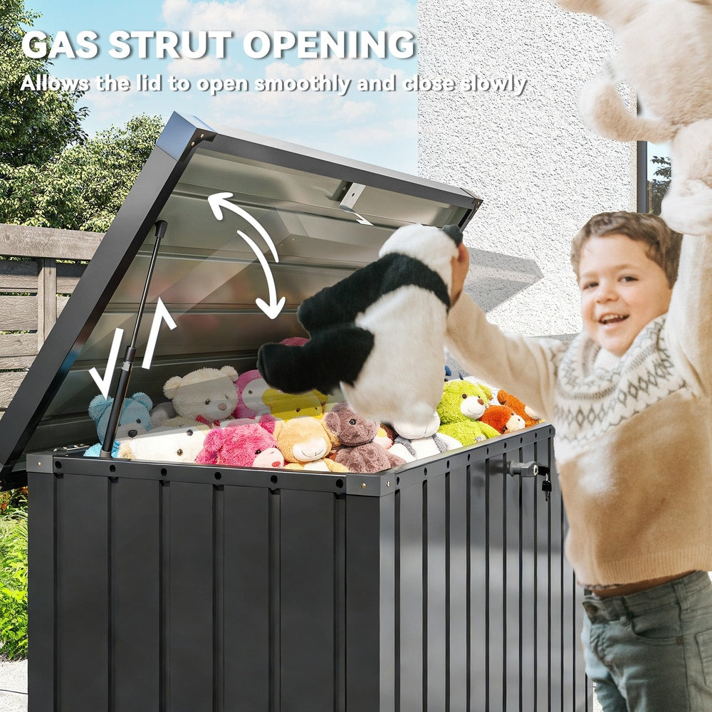 Child adding toys to the black garden storage box with gas strut opening