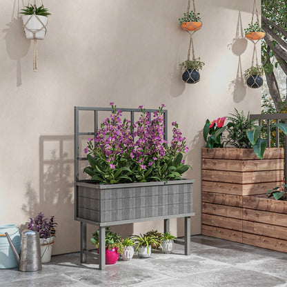 The garden planter placed on a patio with purple flowers and other plants nearby