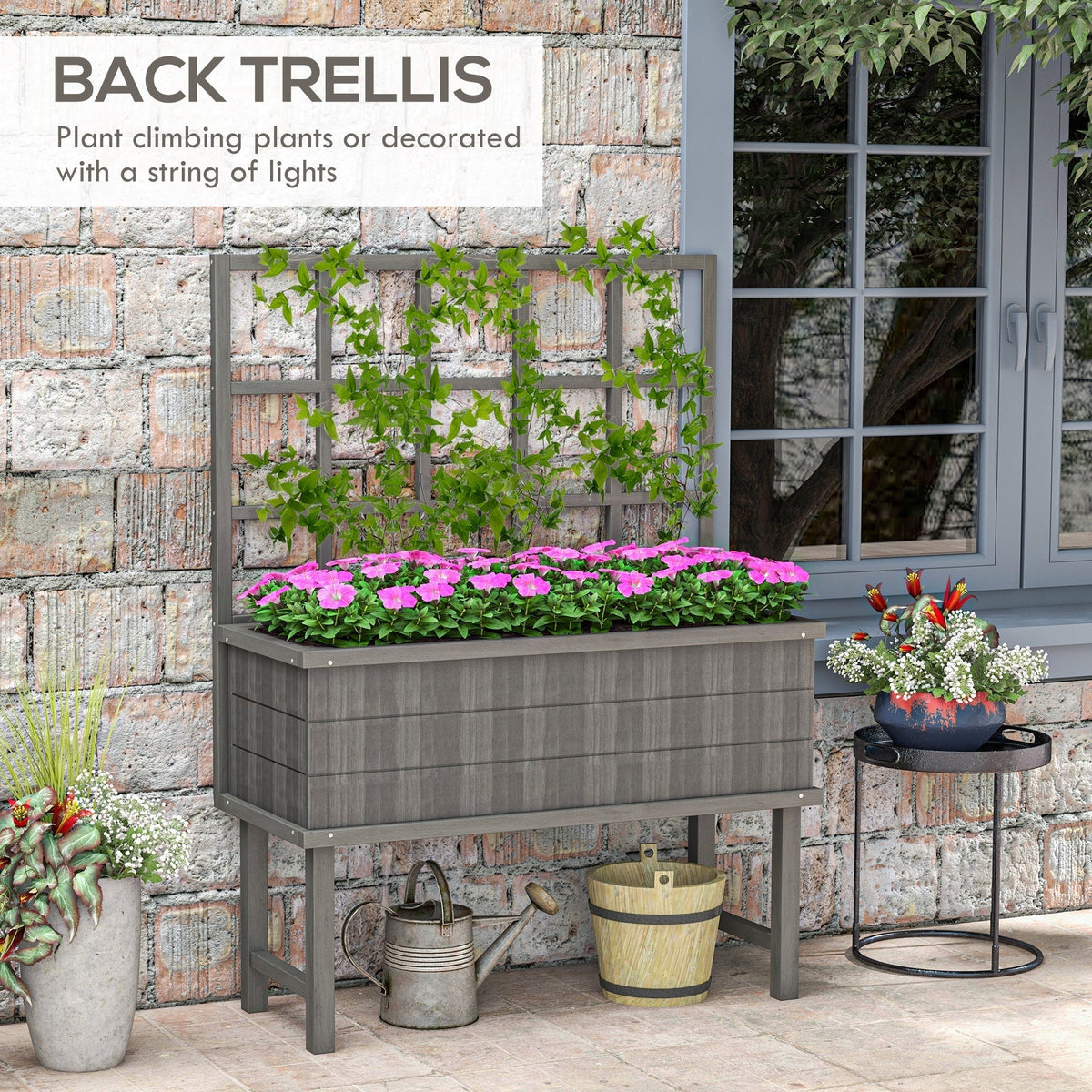 The garden planter standing against a brick wall with climbing green vines on the trellis