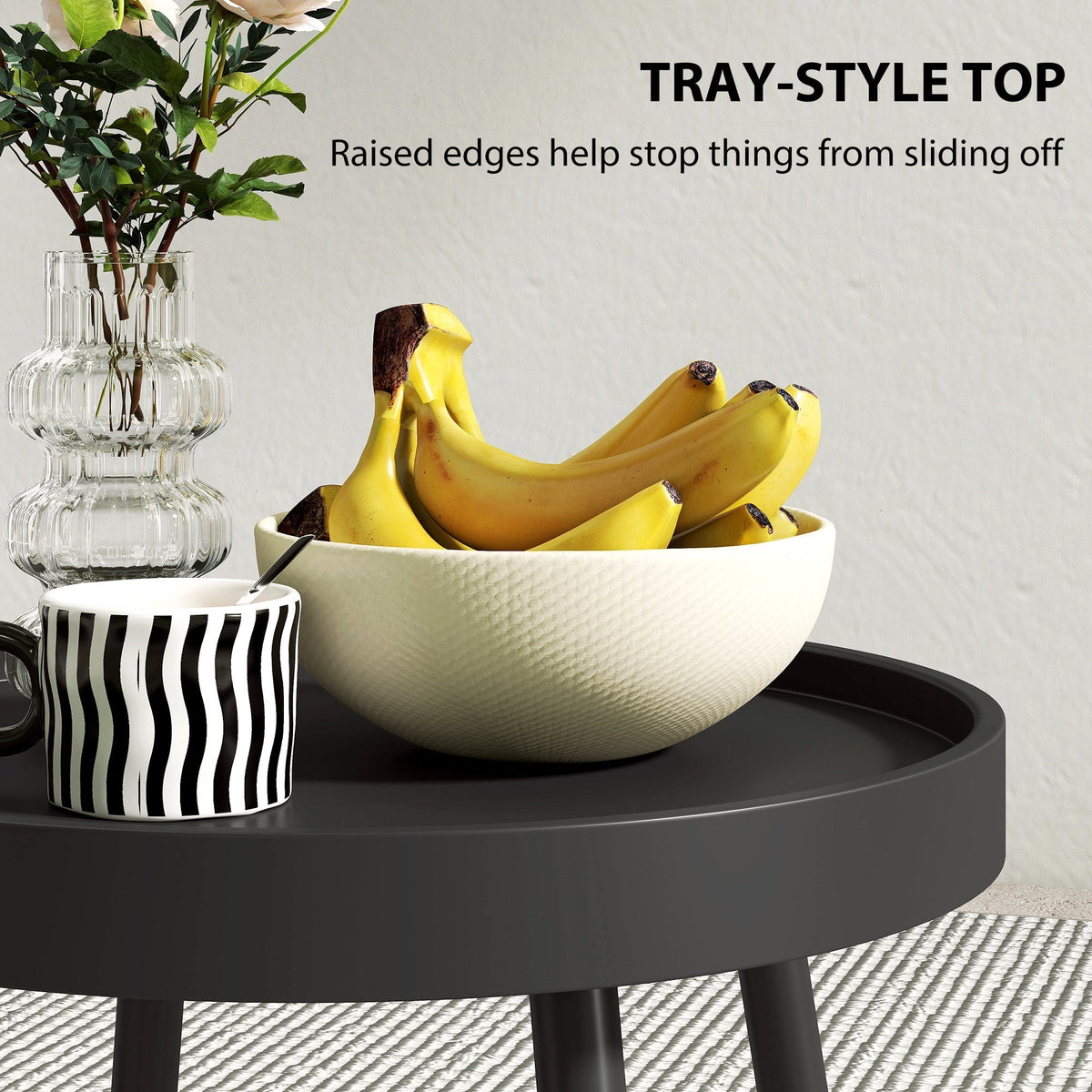 Close-up of the black round garden table showing the tray-style top with raised edges